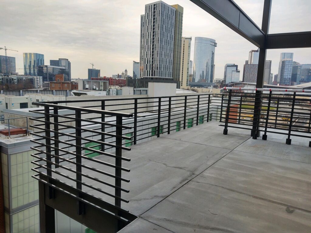 a balcony with a railing and a city skyline