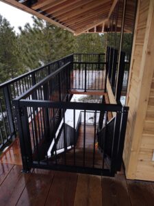 a deck with a railing and trees