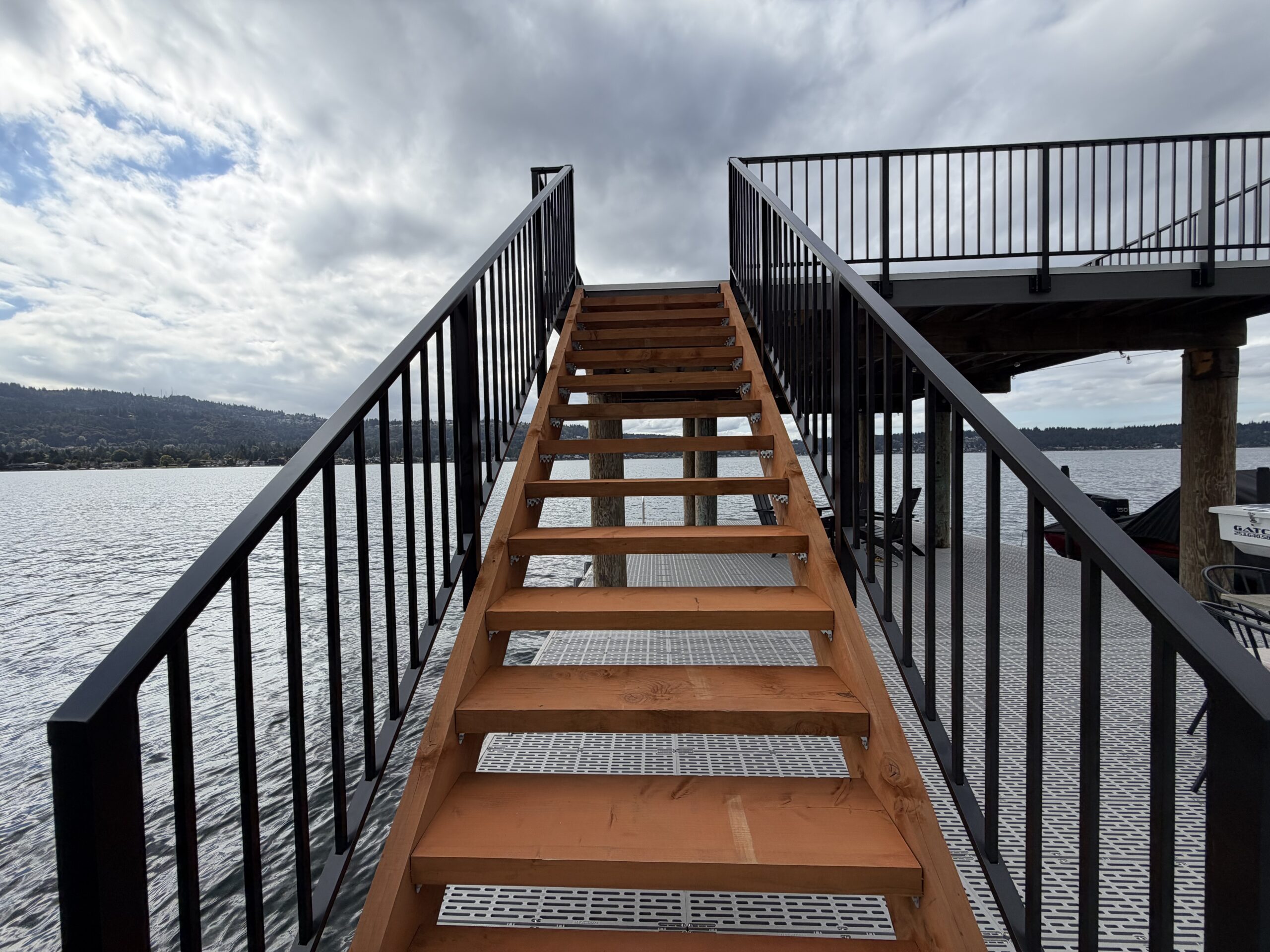 Black aluminum stair railings leading to the raised dock deck